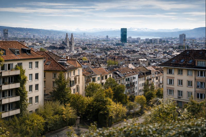 Wohnquartier in Zürich mit Mehrfamilienhäusern und Blick über die Stadt – typische Wohnsituation für Mieter